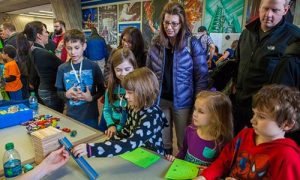 Parents and children participate in a hands-on educational event at the lab